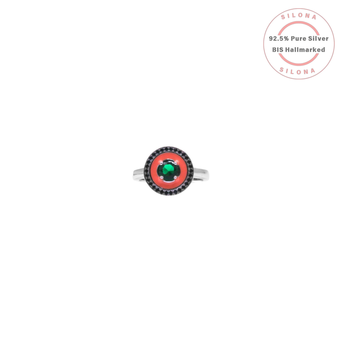 A modern silver ring featuring a central emerald-green stone, set in coral-red enamel and surrounded by a halo of black stones, on a white background.