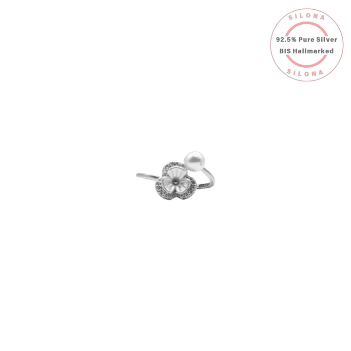 A modern bypass ring in 92.5 silver, featuring a Mother of Pearl clover motif with a Cubic Zirconia halo on one end and a single white pearl on the other, on a white background.