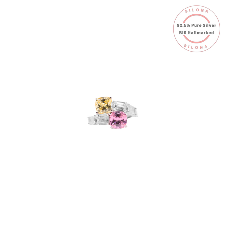 Modern two-stone Toi et Moi ring in 92.5 silver with a cushion-cut pink and yellow cubic zirconia and baguette accent stones, on a white background.
