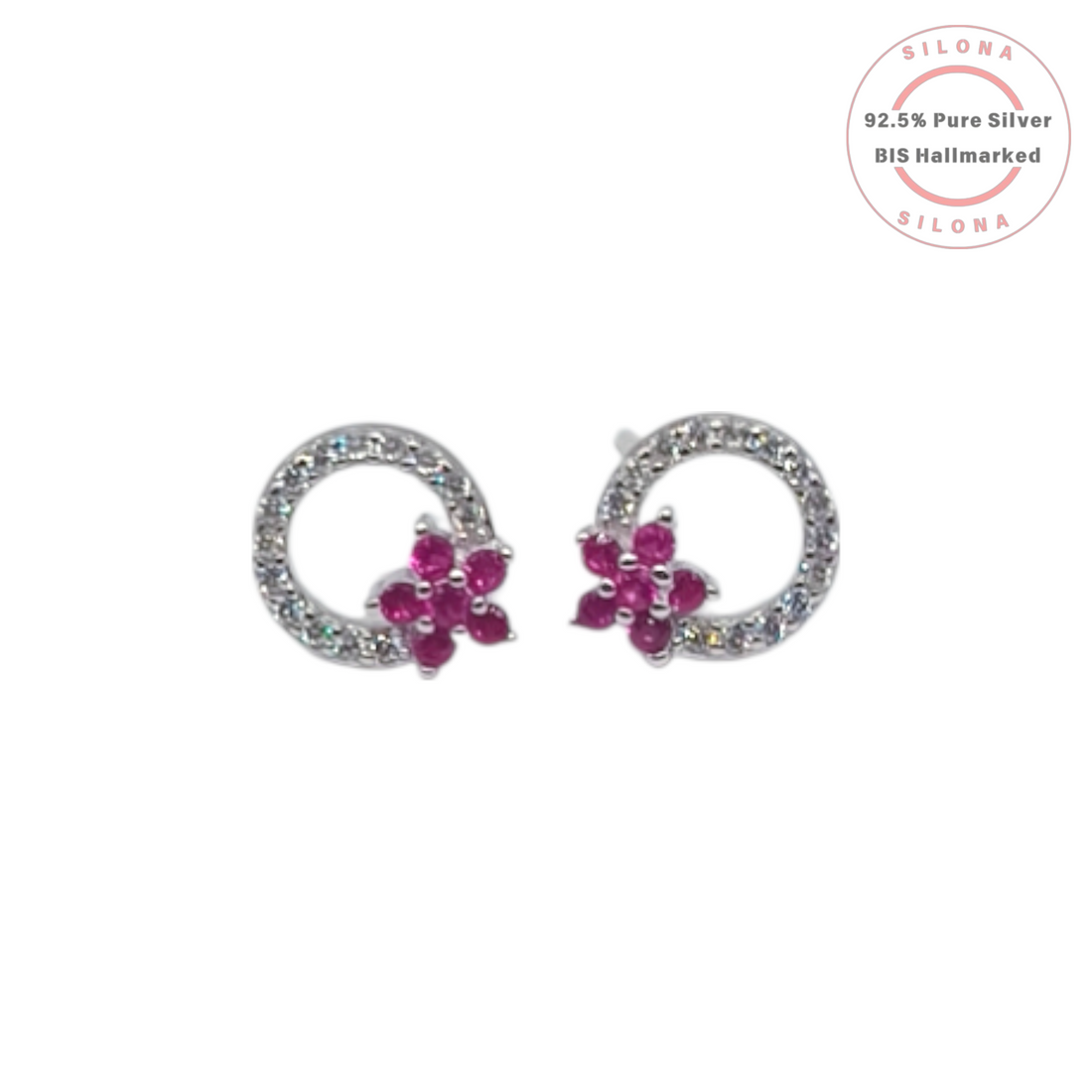 A pair of Silona silver stud earrings featuring a pavé crystal loop with a ruby-hued floral cluster on a white background.