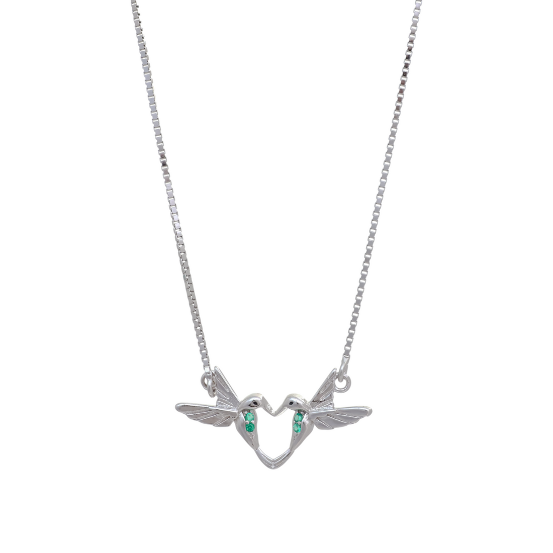 Silver chain necklace displaying two facing hummingbird figures forming a heart shape accented with green gemstones.