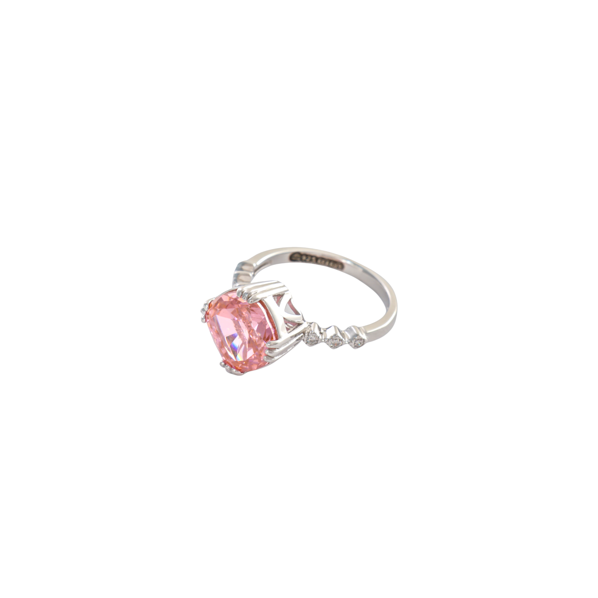 Warm coral pink cushion cut gemstone set on a scroll textured silver ring.