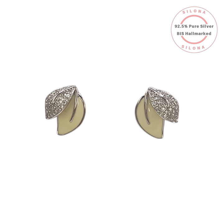 A pair of Silona silver stud earrings shaped like overlapping leaves, one with creamy enamel and one with pavé set cubic zirconia, on a white background.