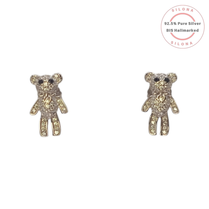 A pair of pavé cubic zirconia teddy bear stud earrings in 92.5 silver with a gold-tone bow accent, on a white background.