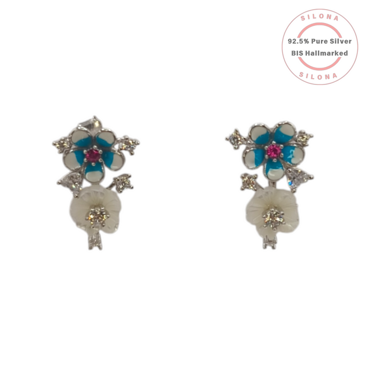 A pair of Enamel Floral Bouquet Earrings, featuring turquoise and white enamel flowers with a ruby-hue stone, and a carved mother-of-pearl flower, crafted in 92.5 sterling silver.