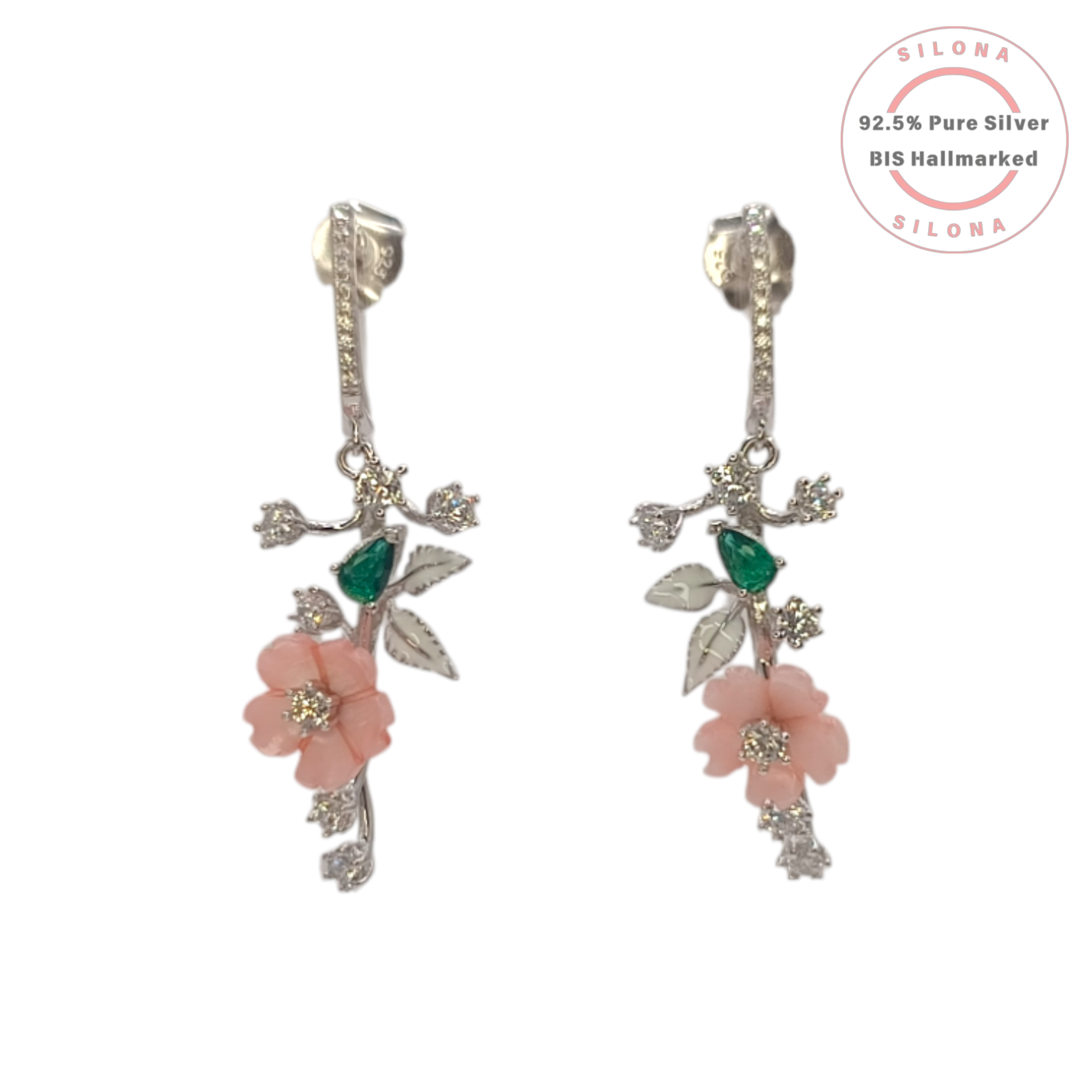 A pair of Silona's Blushing Bloom Floral Drop Earrings, featuring pink carved flowers, green stones, and white enamel leaves on a 92.5 silver vine design against a white background.