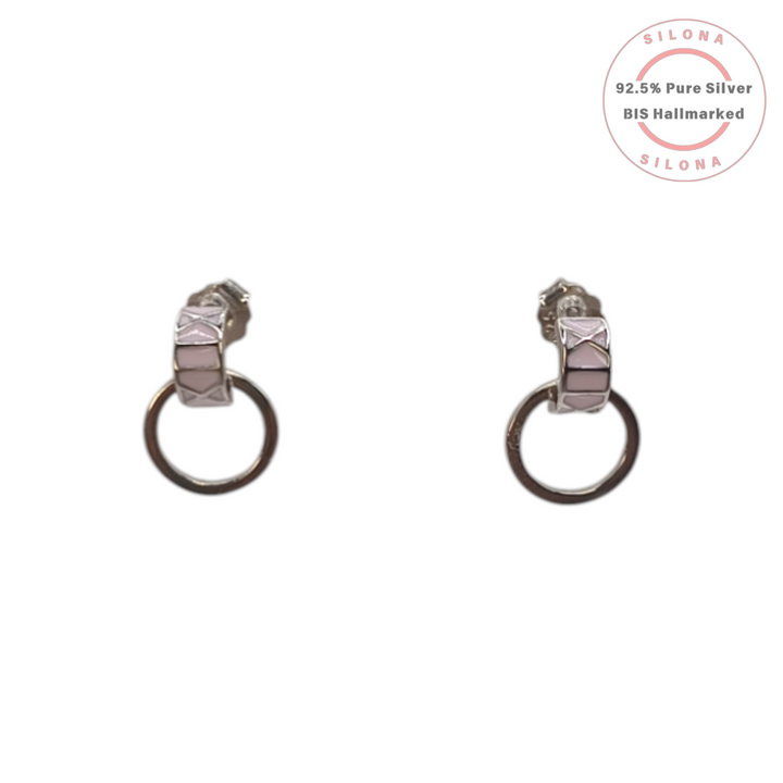 A pair of Silona modern hoop drop earrings in 92.5 silver, featuring a stud with a blush pink geometric enamel pattern and a dangling silver hoop, on a white background.