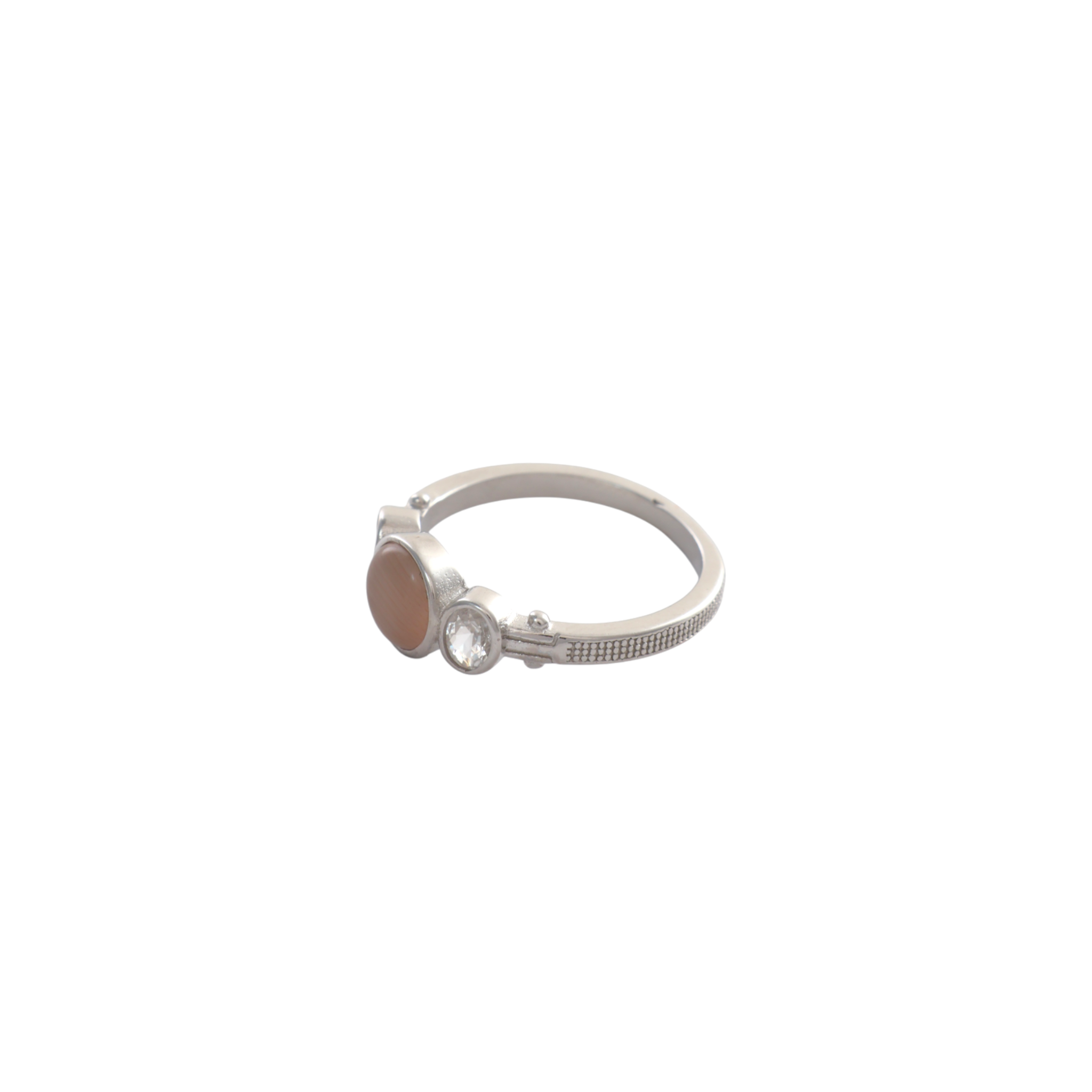 Round peach-colored smooth cabochon flanked by oval clear gems set in silver bezels.