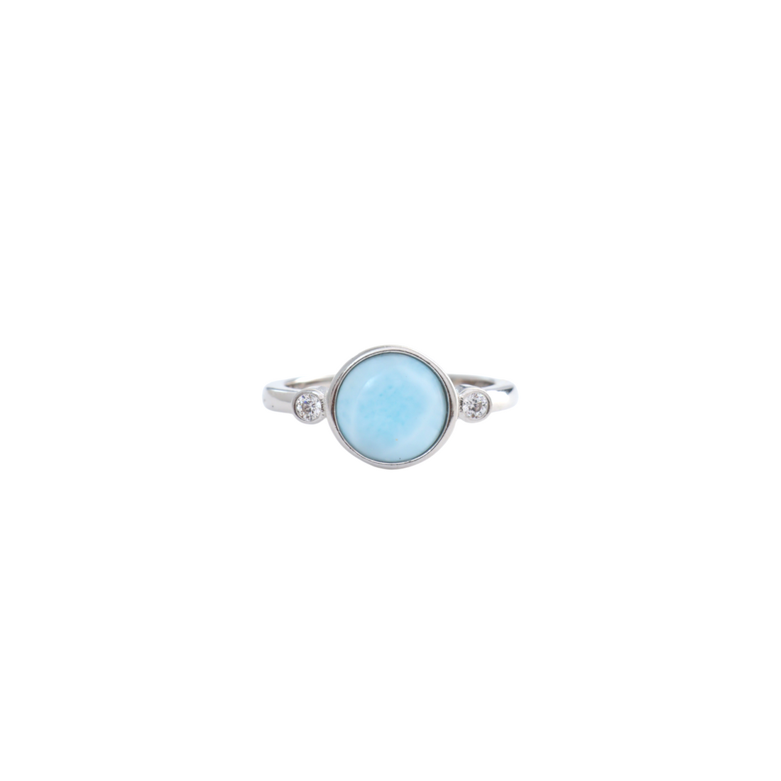 Round light blue larimar cabochon flanked by two small bezel set clear stones on a silver band.