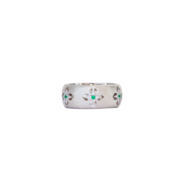 Wide satin brushed silver ring featuring carved starburst cutouts with green accent stones.