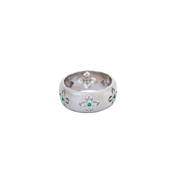 Wide satin brushed silver ring featuring carved starburst cutouts with green accent stones.
