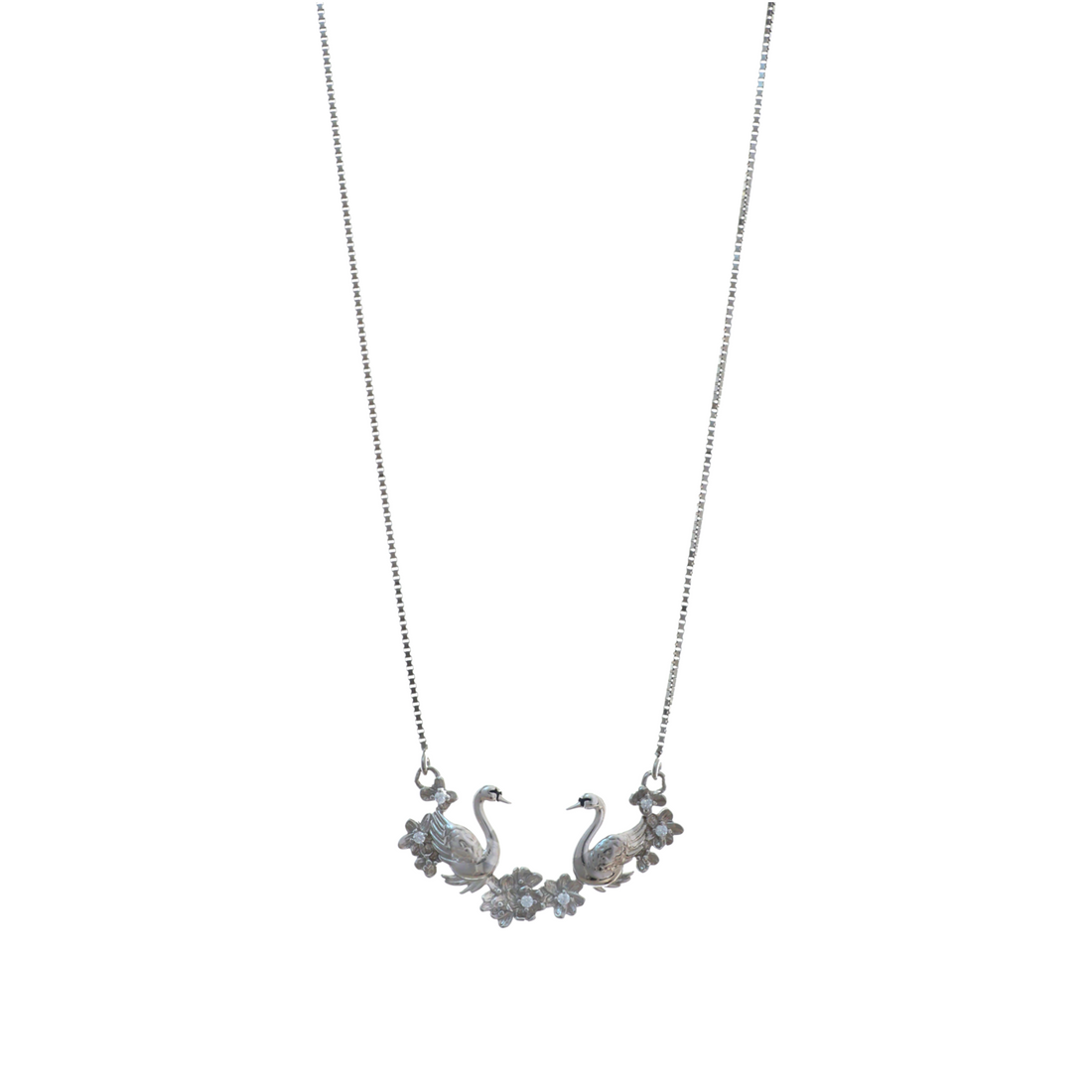 Silver chain necklace with a horizontal curved pendant featuring two facing swans and silver flowers.