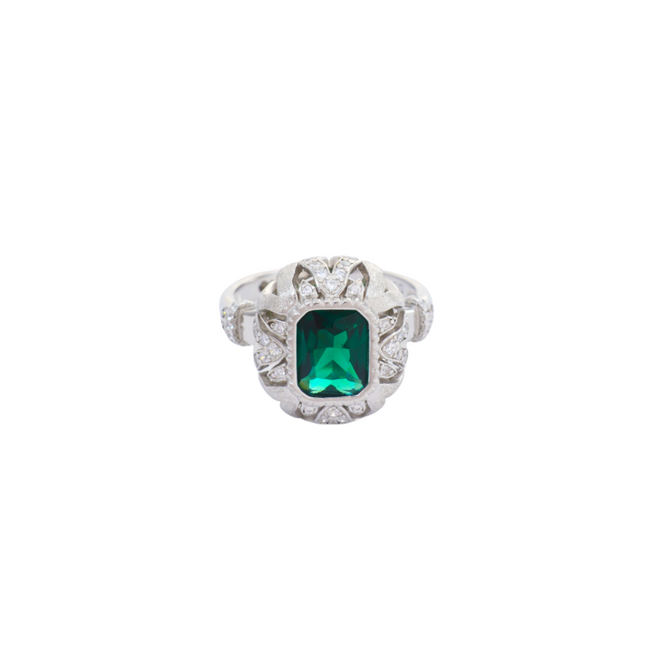 Emerald cut green stone encased in an intricate filigree scrollwork silver setting with pave accents.