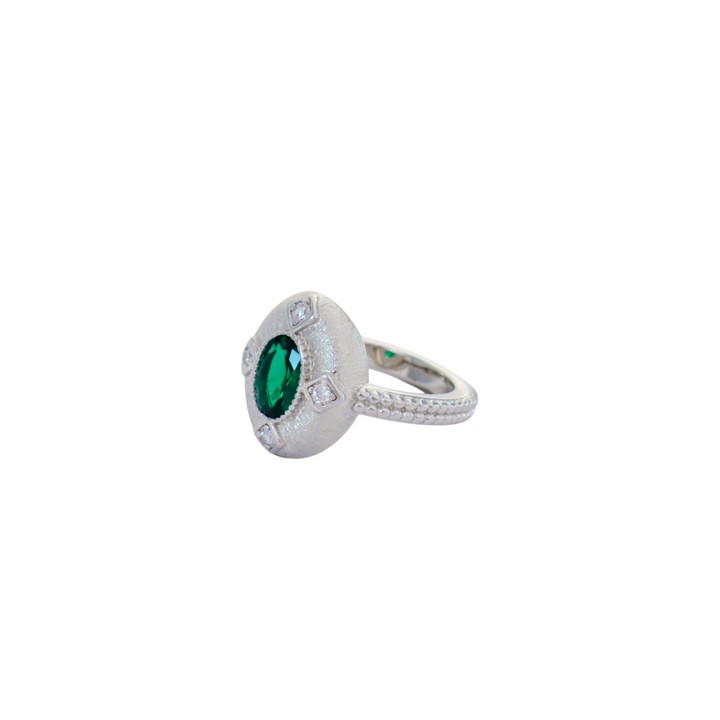 Oval emerald green stone set inside a brushed silver medallion with pave corner points.