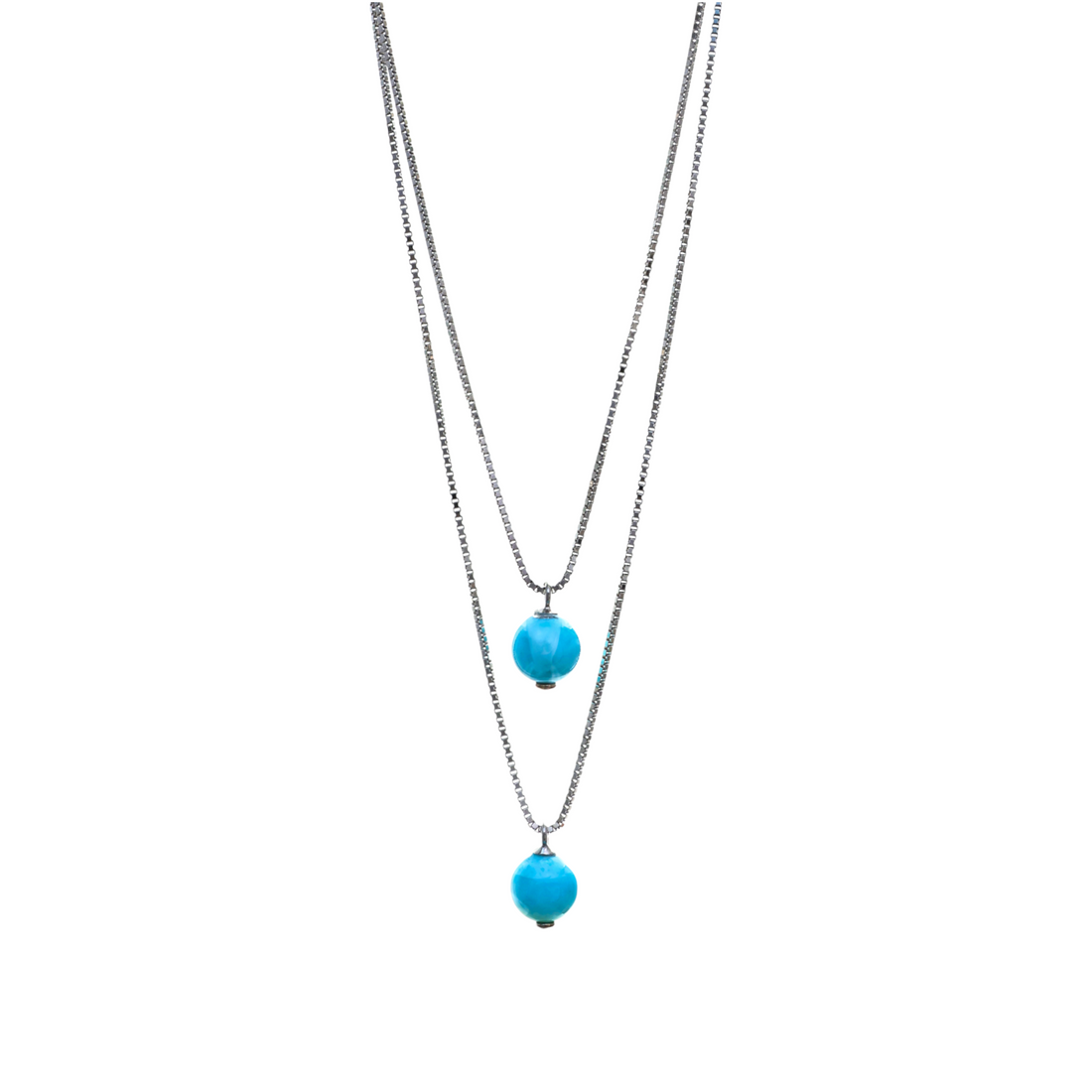 A double-layered silver chain necklace featuring two suspended round turquoise-blue gemstone beads at alternating lengths.