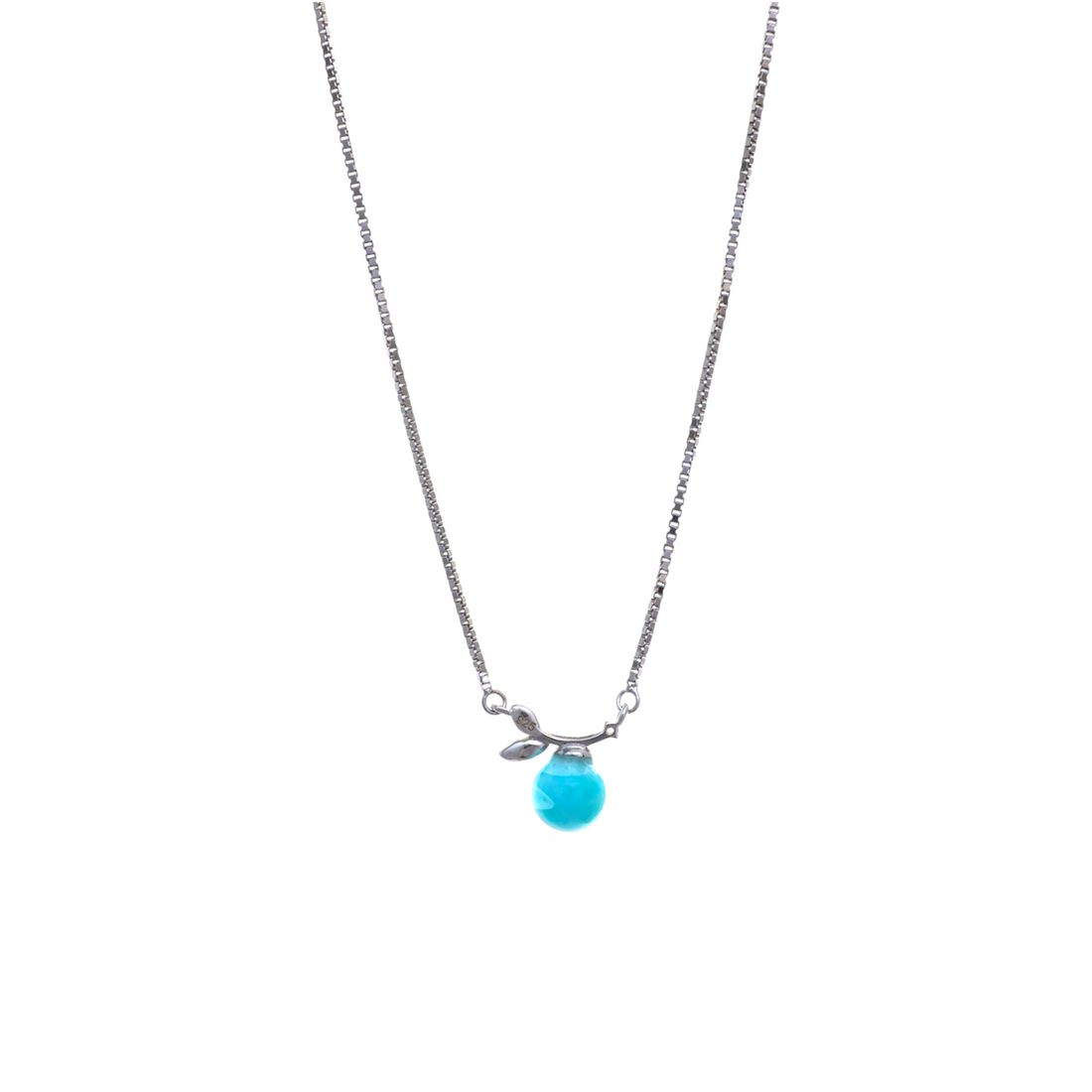 A delicate silver chain featuring a small branch with a leaf detail suspending a smooth teardrop blue gemstone.