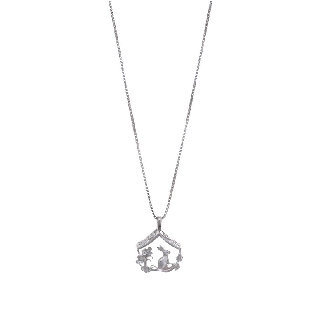 A silver chain necklace with a house-shaped silhouette frame housing a seated rabbit and floral embellishments.